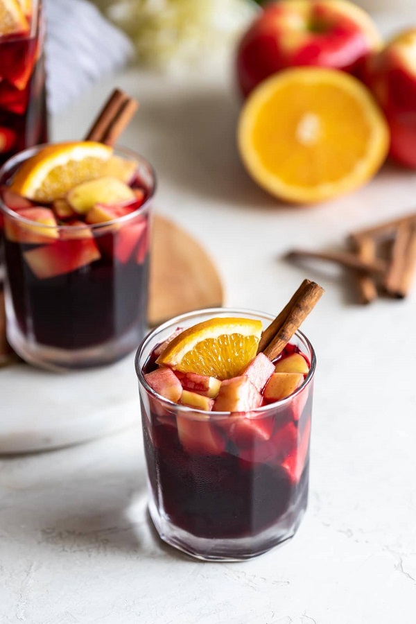 spiced pear sangria easy cocktail recipe with holiday decor surrounding the cup